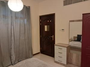 a bedroom with a bed and a mirror and a door at Top House Zayed Airport - Free Taxi Drop in Abu Dhabi