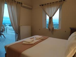 a bedroom with a bed with two towels on it at VILA KALIELAIA in Mouzákion