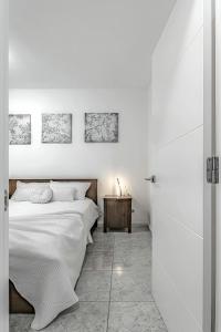 a white bedroom with a bed and a table at Tenerifeopenhome Ocean View Costa Adeje in Adeje