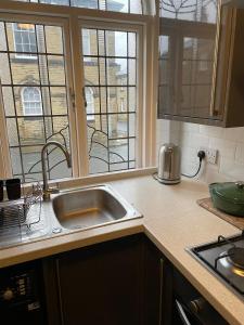 a kitchen counter with a sink and a window at Cosy 1BD Heritage Cottage in Saltaire, Shipley in Shipley