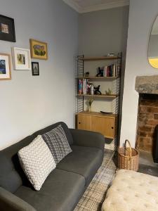 a living room with a couch and a book shelf at Cosy 1BD Heritage Cottage in Saltaire, Shipley in Shipley