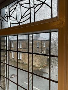 a view of a building through a window at Cosy 1BD Heritage Cottage in Saltaire, Shipley in Shipley