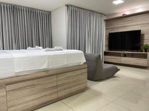 um quarto com uma cama e uma televisão de ecrã plano em Lounge 22 Home Design em Goiânia