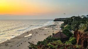 a group of people on a beach at sunset at AARONIC STAY in Varkala