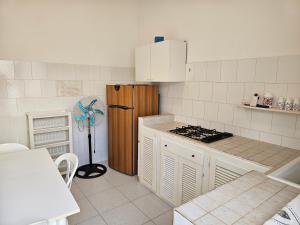 una cucina bianca con piano cottura e frigorifero di Residence Arlecchino a Lido Conchiglia
