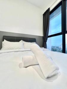 ein weißes Bett mit zwei weißen Kissen und einem Fenster in der Unterkunft Urban Suite 3R2B 8Pax Georgetown in Jelutong