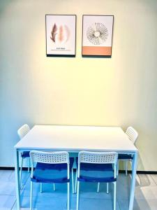 einem blauen Tisch mit zwei Stühlen und zwei Bildern an der Wand in der Unterkunft Urban Suite 3R2B 8Pax Georgetown in Jelutong