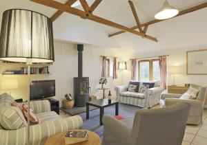 a living room with couches and a fireplace at Crofters in Blaxhall