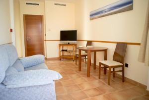 a living room with a couch and a table and a tv at La Galerica in Puerto de Mazarrón