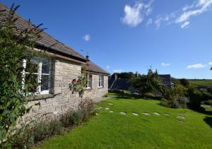 a brick house with a yard next to a building at Wild Hill in Worth Matravers