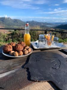 stół z dwoma talerzami jedzenia i butelką soku pomarańczowego w obiekcie U Sognu w mieście Muro