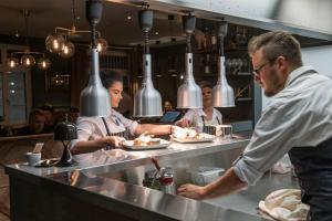 uno chef che prepara il cibo al bancone di un ristorante di Apartment Spedition a Thun