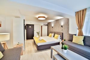 a hotel room with a bed and a couch at Garni House 46 Plus in Belgrade