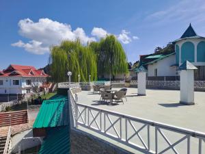 a patio with tables and chairs on a bridge at Galleu Hill Resort, Kufri Himalayan view resort in Cheog