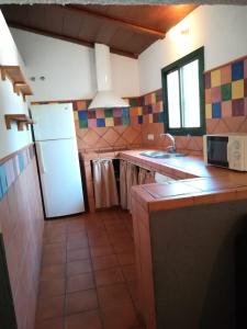 una cucina con un frigorifero bianco e un lavello di El Mesón de Higuera de la Sierra a Higuera de la Sierra