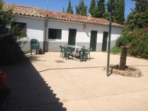 un patio con mesa y sillas frente a un edificio en El Mesón de Higuera de la Sierra, en Higuera de la Sierra