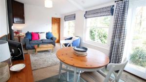 Mulberry Hill Cottage في Nicholaston: غرفة معيشة مع طاولة وأريكة