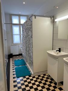 La salle de bains est pourvue d'une douche et d'un tapis bleu. dans l'établissement House Elza, à Ljubljana