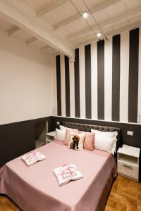 una camera da letto con un letto rosa con due asciugamani di Santa Croce Dream Suites a Firenze