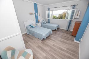 ein kleines Zimmer mit 2 Betten und einem Fenster in der Unterkunft EL EMBARCADERO in Pedreña