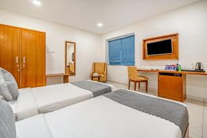 ハイデラバードにあるWESTSIDE HOTEL HiTECH CITYのベッド2台とデスクが備わるホテルルームです。