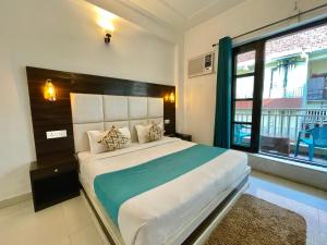 a bedroom with a large bed and a large window at The Wraveler Tapovan , Rooms & Dorms in Rishīkesh