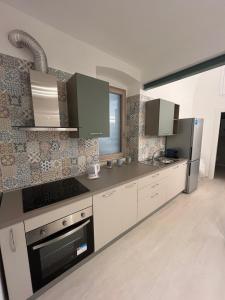 a kitchen with white cabinets and a stainless steel refrigerator at Dimora VistaMare in Giovinazzo