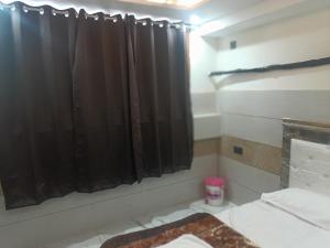 a bathroom with a black shower curtain in a room at Hotel Golden key in Pānīpat