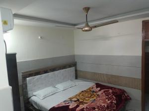 a bed in a room with a ceiling fan at Hotel Golden key in Pānīpat