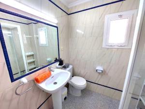 y baño con lavabo, aseo y espejo. en Sol Centro Apartment B, en Sevilla