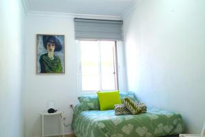 1 dormitorio con una almohada verde y una ventana en Sol Centro Apartment B, en Sevilla