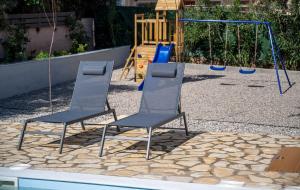 two chairs sitting in front of a playground at Villa Artia in Xiropigado +50 photos