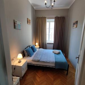 a bedroom with a bed with blue pillows and a window at Novo Mundo in Warsaw