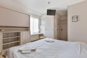 um quarto com uma cama com duas toalhas em Les Tourelles Village de vacances em Asnelles