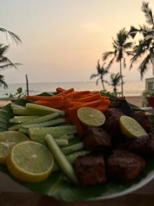 a plate of food with meat and vegetables on the beach at Santa Maria, Trivandrum - An Airport Boutique by the Sea in Trivandrum