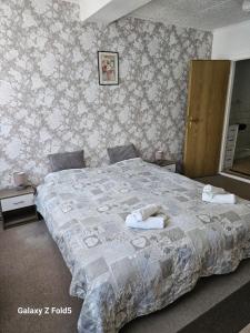 une chambre avec un grand lit avec un papier peint fleuri dans l'établissement Zimmervermietung Freiberg Zentrum, à Freiberg