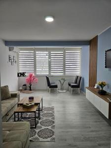 uma sala de estar com um sofá, uma mesa e cadeiras em Apartman Nana em Mostar