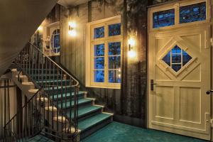 a staircase in a house with a door and windows at Boutique Hotel Spedition a member of DESIGN HOTELS in Thun