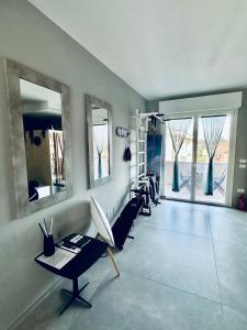 um quarto com uma secretária, cadeiras e janelas em OliVia Rooms Sauna & Gym em Forlì
