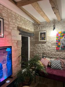 a living room with a couch and a tv at Moonlight cottage france in Courchamps