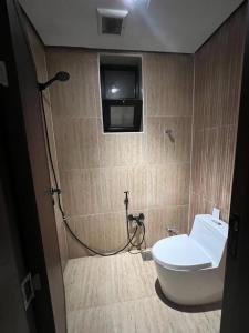 ein Bad mit WC und ein TV an der Wand in der Unterkunft الرياض - حي قرطبة in Riad