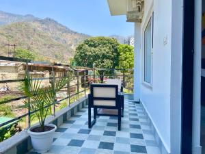 a chair on a balcony with a view of a mountain at Hotel Wraveler Inn Rishikesh in Rishīkesh