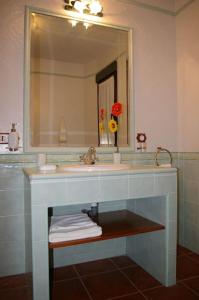 een badkamer met een wastafel en een spiegel bij Casa Rural Cristina II in San Pablo de los Montes