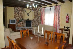 un soggiorno con tavolo da pranzo con candele di Casa Rural Cristina II a San Pablo de los Montes