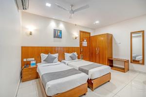 a bedroom with two beds and a mirror at Westside Hotel Gachibowli in Hyderabad