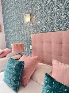 um quarto com duas camas e um sofá com almofadas em Hotel Mirabeau em Tours