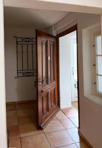 un couloir avec une porte en bois et du carrelage. dans l'établissement Haus am Berzdorfer See, à Görlitz