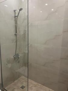 a shower with a glass door next to a tub at Amman in Amman