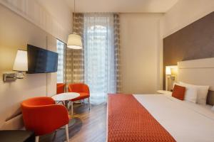 a hotel room with a bed and a table and chairs at Ikonik Parlament in Budapest