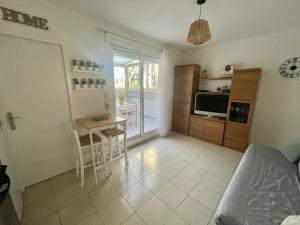 a living room with a table and a kitchen at Appart CLIM , WIFI, PLAGE 200 mètres in Argelès-sur-Mer